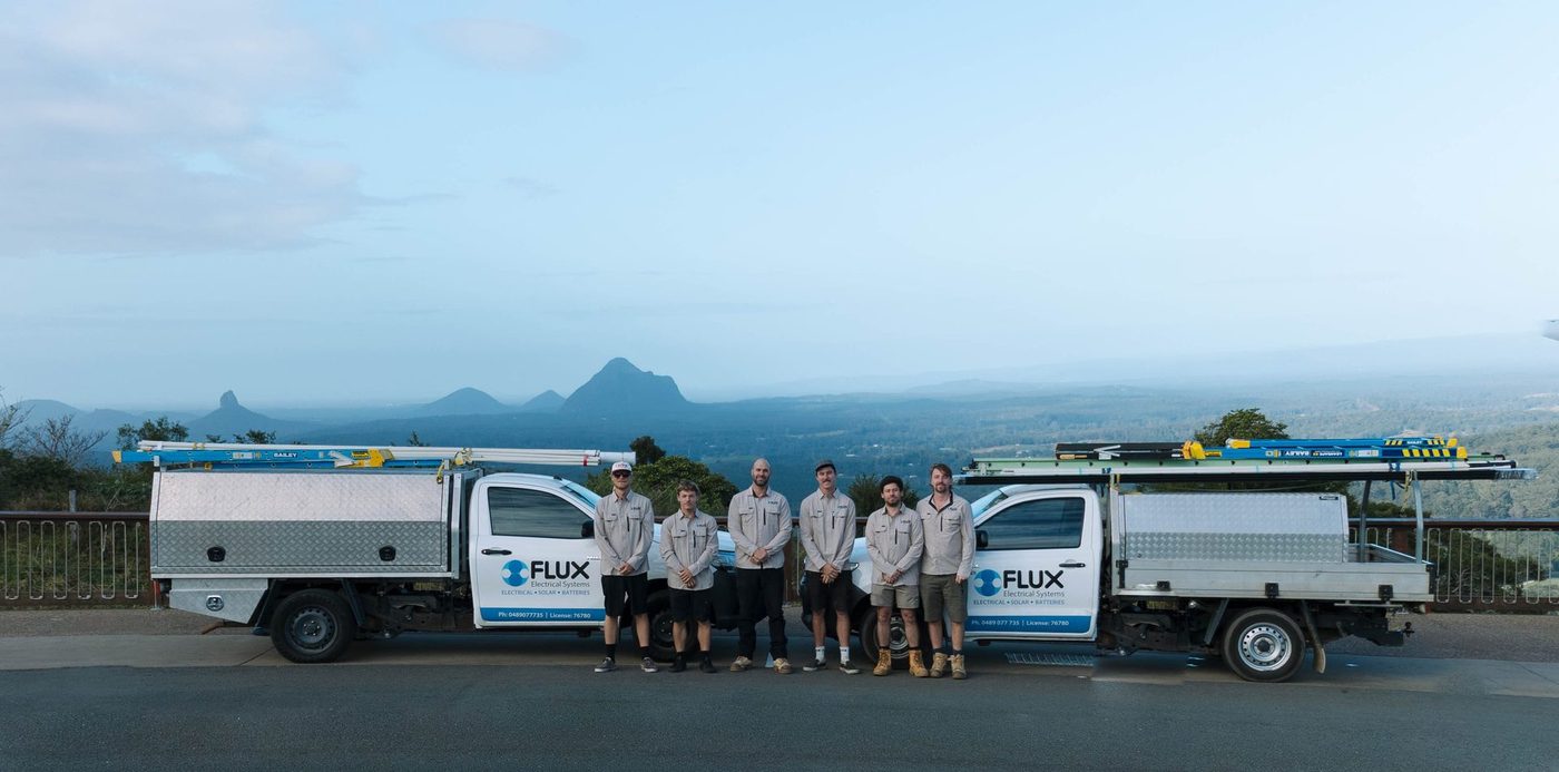 The Flux Electrical team standing in front of two Flux utes